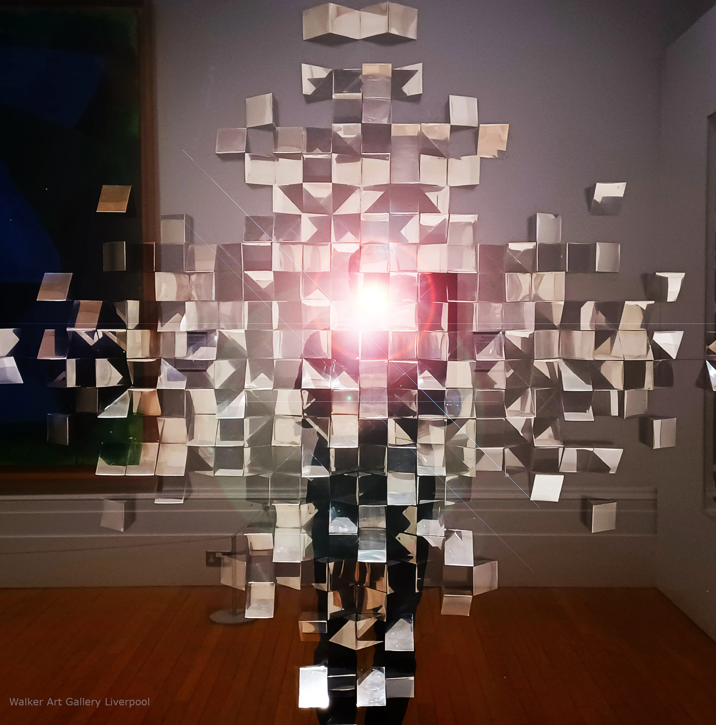 Modern art picture shows many squares and triangles made of mirrors all stuck close together in a collage style and at different angles, which looks very unusual and cool.