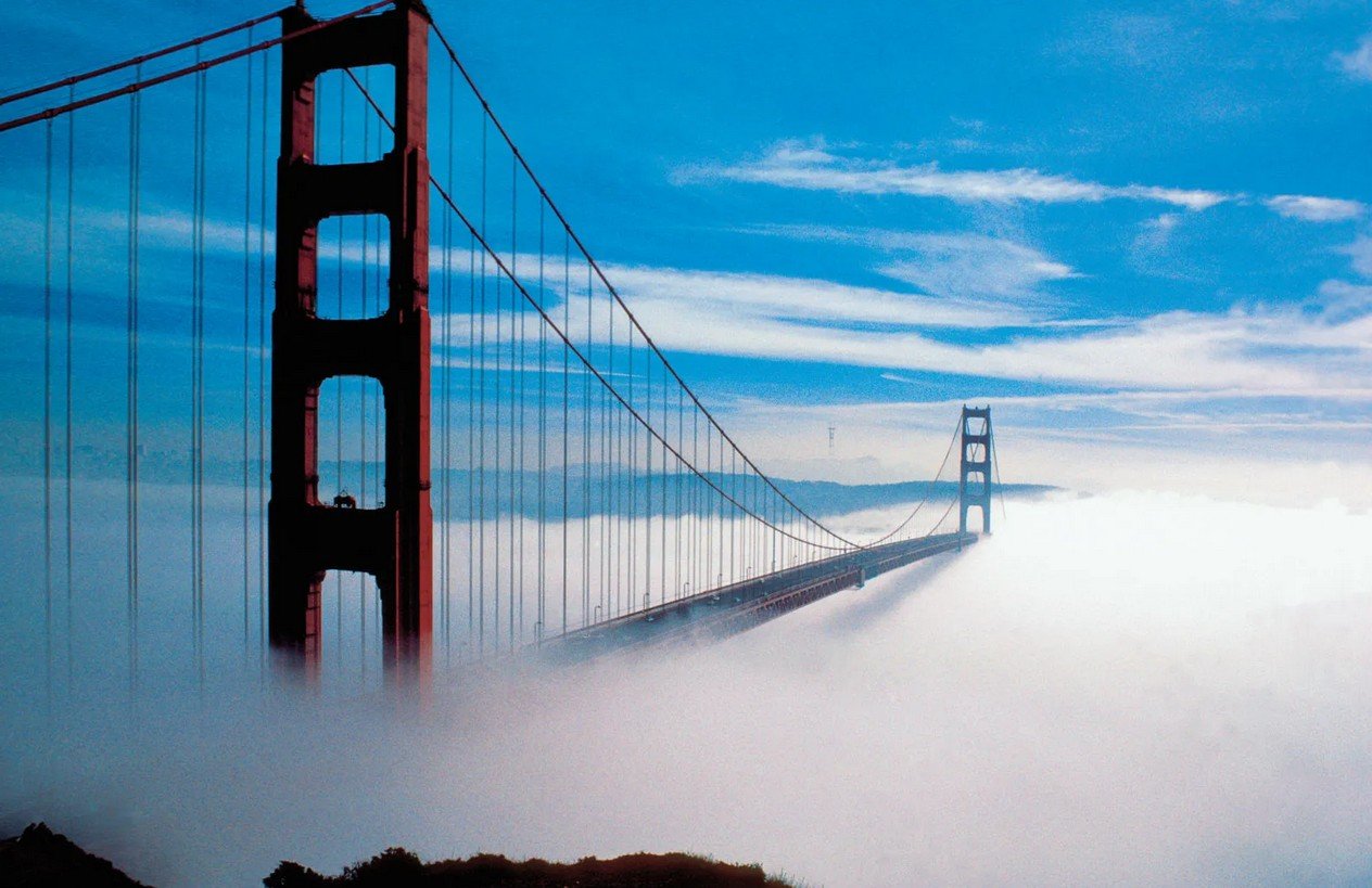 Another beautiful photograph of the bridge. This one is almost identical to the previous one. The bridge is towering above the clouds, but this photo was taken with an old 35mm film analogue SLR camera, so this image looks a bit grainy and a little bit distorted, but it is still a wonderful photograph.