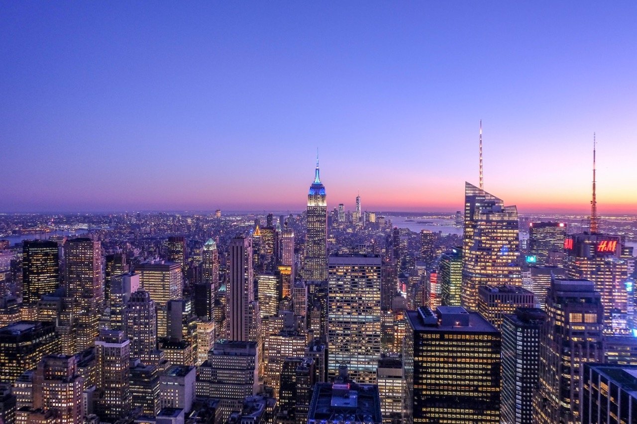 Beautiful photo showing the modern NYC skyline at night. The buildings are towering into the sky and shining with all their lights.