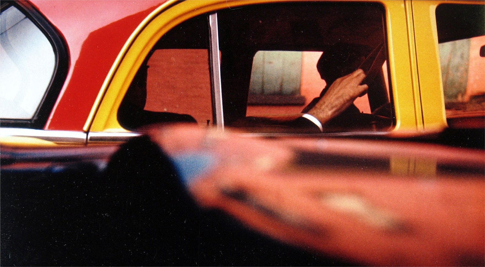 Photo shows the frame of an old red and yellow New York taxi